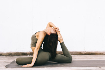 Attractive model in yoga pose on white background in sexual clothes