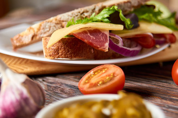 Sandwich with bacon, cheese, garlic, jalapeno pepper and herbs on a plate