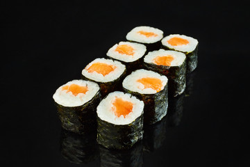 Classical roll sushi maki with salmon isolated on black background for menu. Japanese food