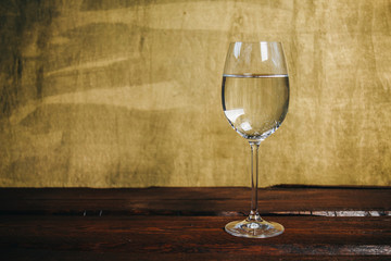 cropped glass of white wine on a rustic wooden brown background. rest, holiday, party. alcoholic drink closeup. copy space
