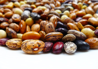 Bean mix for backgrounds or textures. Assorted dried beans close up. Variety of protein rich colorful raw dried beans. Multicolored mixed dried beans on a white background.