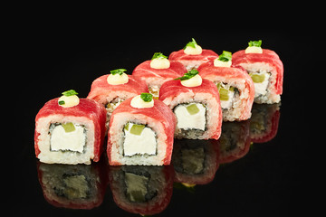 Philadelphia roll sushi with tuna, avocado, cream cheese on black background for menu. Japanese food