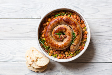 Italian sausage - salsiccia fresca, with bean stew and rosemary on a white background