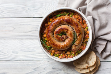 Italian sausage - salsiccia fresca, with bean stew and rosemary on a white background