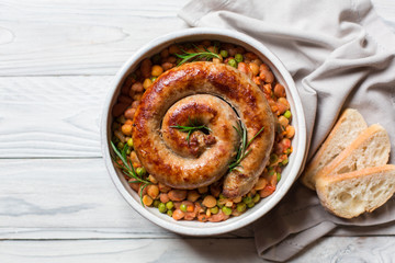 Italian sausage - salsiccia fresca, with bean stew and rosemary on a white background