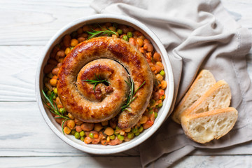 Italian sausage - salsiccia fresca, with bean stew and rosemary on a white background