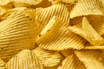 Background of juicy corrugated potato chips close-up
