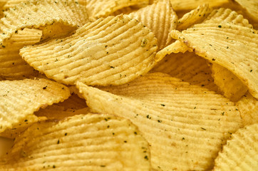 Background of juicy corrugated potato chips close-up