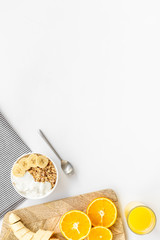 granola with banana slices and orange juice for breakfast on blue background top view copyspace