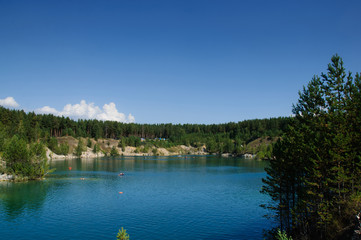 Fototapeta premium mountain lake in the summer at noon with vacationers and swimming tourists