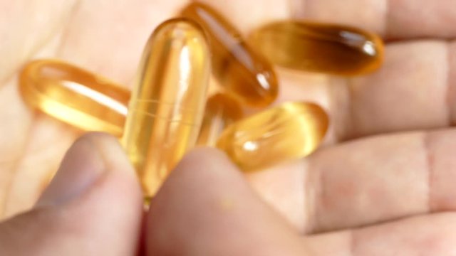 Vitamins Omega 3 in capsules on the hand. Take fish oil. take hand vitamins. Healthy lifestyle. Health heart and blood vessels.