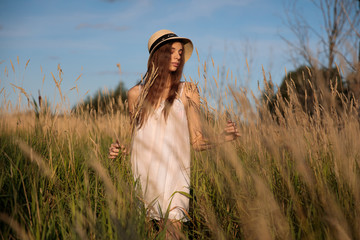 A girl walks in a golden wheat field