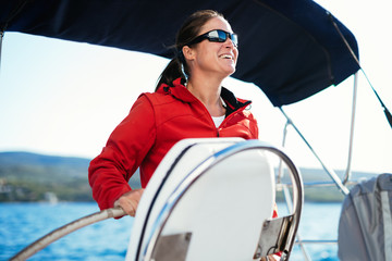 Attractive strong woman sailing with her boat