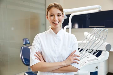 Foto op Plexiglas Tandarts Mooie gelukkige jonge vrouw arts in medisch tandartscentrum.