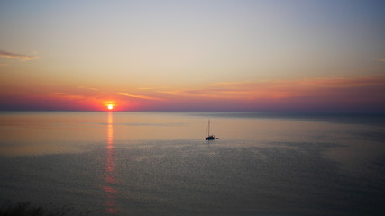 Sunrise over the sea with sailing boat on the water