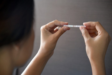 Woman holding positive pregnancy test.