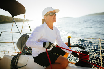 Attractive strong woman sailing with her boat