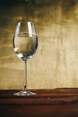 cropped glass of white wine on a rustic wooden brown background. rest, holiday, party. alcoholic drink closeup. copy space