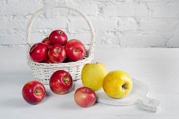 Apples in basket on white wall background.
