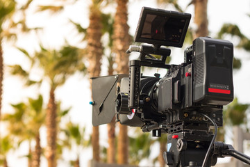 Movie camera on set in exterior with palm trees