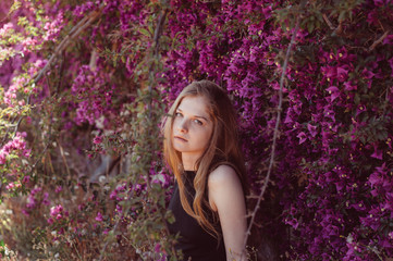 Portrait of girl among purple bougainvillaea