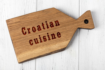Wooden cutting board with inscription. Concept of croatian cuisine
