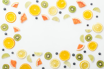 Flat lay with cut fruits and blueberries on white surface