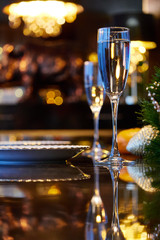 Glasses with a drink standing on the table. Festive table setting with a beautiful reflection.