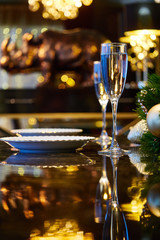The table decorations with two glasses of champagne. Mirror table and beautiful lighting.