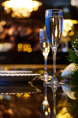 Glasses with a drink standing on the table. Festive table setting with a beautiful reflection.