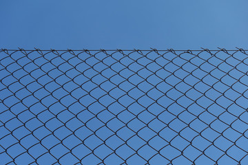 rusty chain link fence and blue sky background