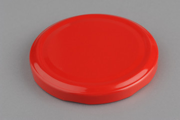 Screw cap for glass jars. For canning, canned food. Red cap on gray background