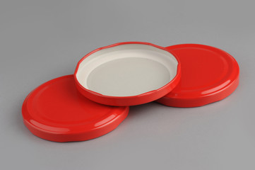 Screw caps for glass jars. For canning, canned food. Red caps on gray background