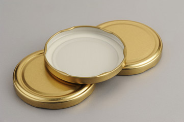 Screw caps for glass jars. For canning, canned food. Golden caps on gray background