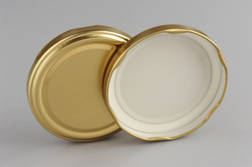 Screw caps for glass jars. For canning, canned food. Golden caps on gray background