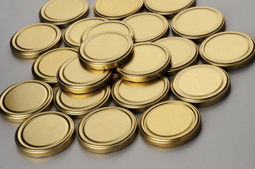 Screw caps for glass jars. For canning, canned food. Golden caps on gray background