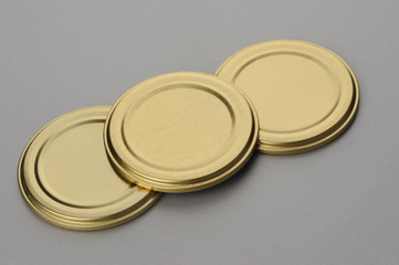 Screw caps for glass jars. For canning, canned food. Golden caps on gray background