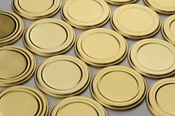 Screw caps for glass jars. For canning, canned food. Golden caps on gray background