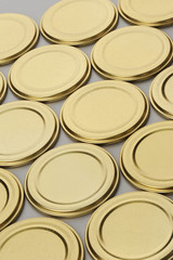 Screw caps for glass jars. For canning, canned food. Golden caps on gray background