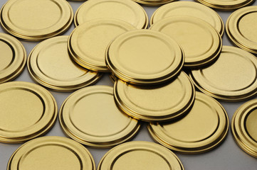 Screw caps for glass jars. For canning, canned food. Golden caps on gray background