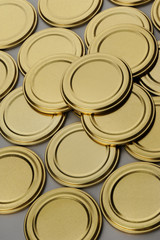 Screw caps for glass jars. For canning, canned food. Golden caps on gray background