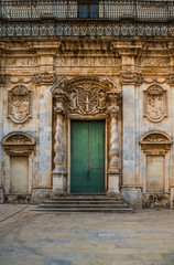 Fototapeta na wymiar Old wooden door of the cathedral in the historic center of Ortigia island in Syracuse, Sicily, Italy