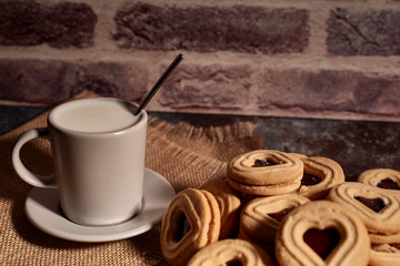 delicious bunch of sweet cookies next to a rich cup of hot milk