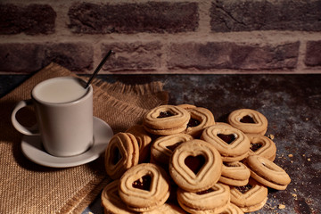 delicious bunch of sweet cookies next to a rich cup of hot milk