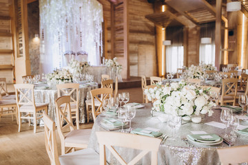 on the banquet table are plates, cutlery, glasses and flower arrangements