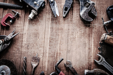 grungy old tools on a wooden background