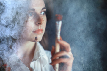 Fototapeta premium Young artist girl at work in the workshop brush paints canvas inspiration