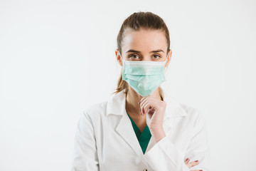 Young nurse in a scrub uniform wearing a face mask.
