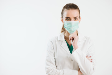 Young nurse in a scrub uniform wearing a face mask.