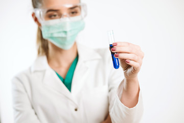 Fototapeta premium Young nurse holding a test tube, testing liquid.